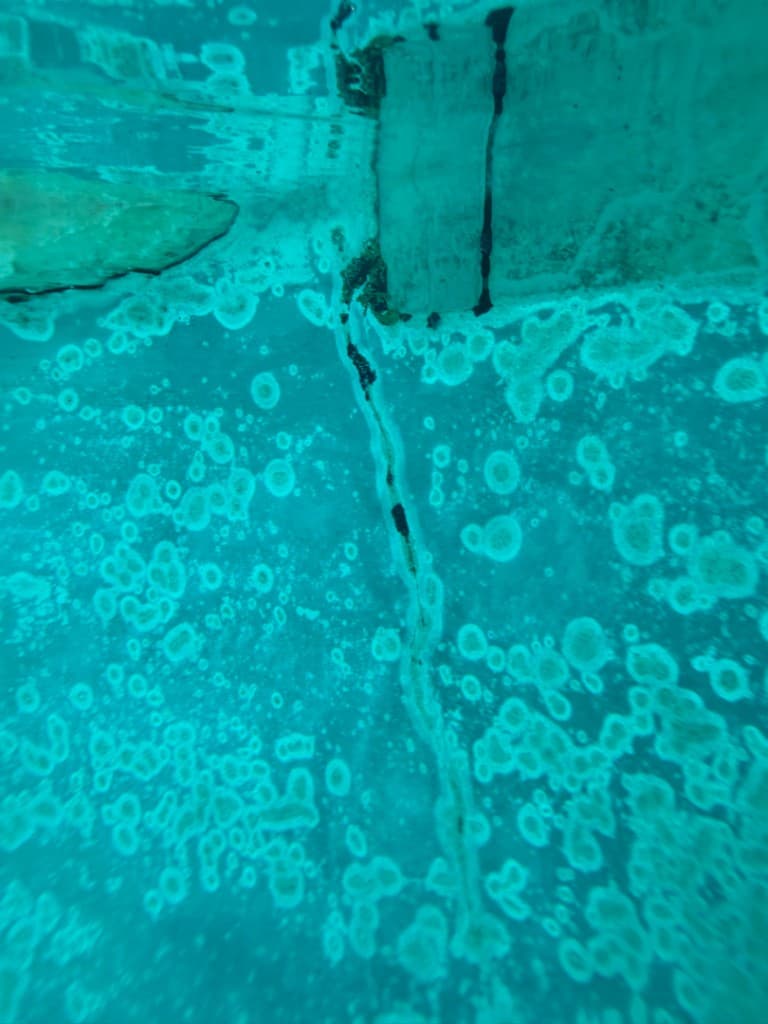 Underwater crack identified at rockwork junction during leak detection — Spicewood