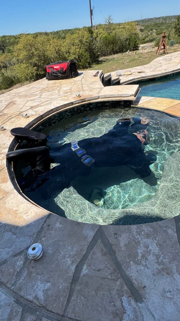 Diver performing underwater pool leak inspection in Central Texas