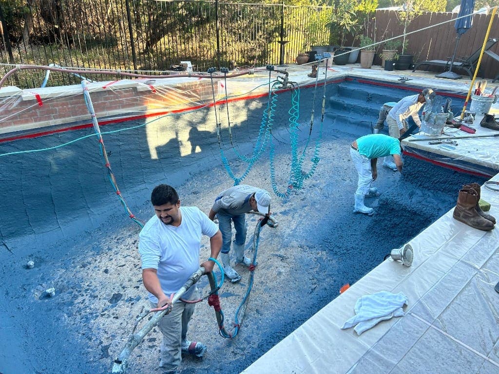 Pool renovation crew applying new plaster finish in Central Texas