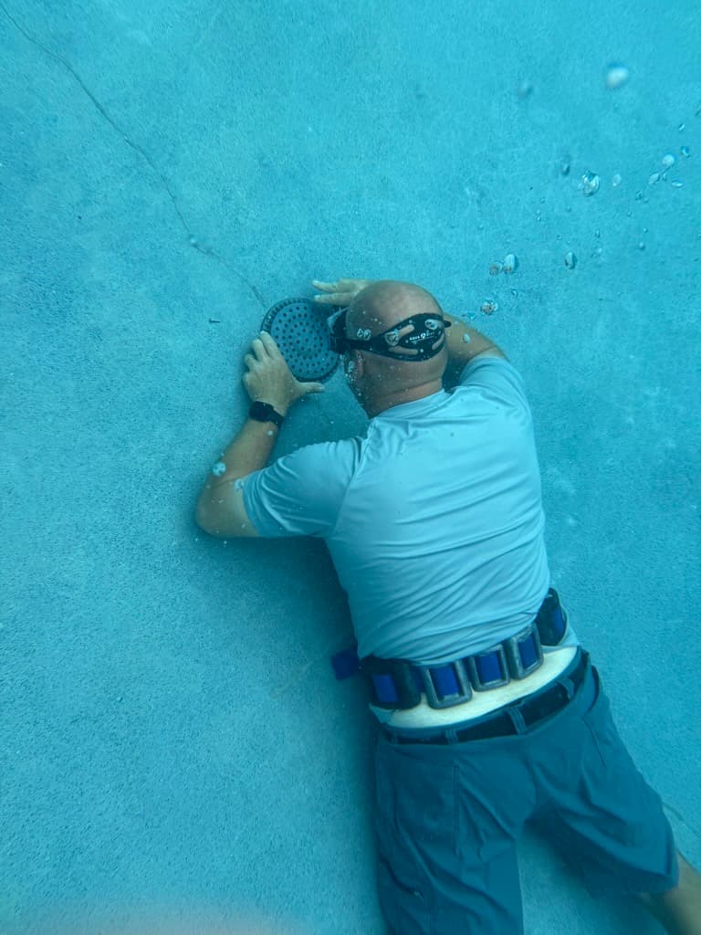 Diver performing underwater pool leak inspection in Central Texas